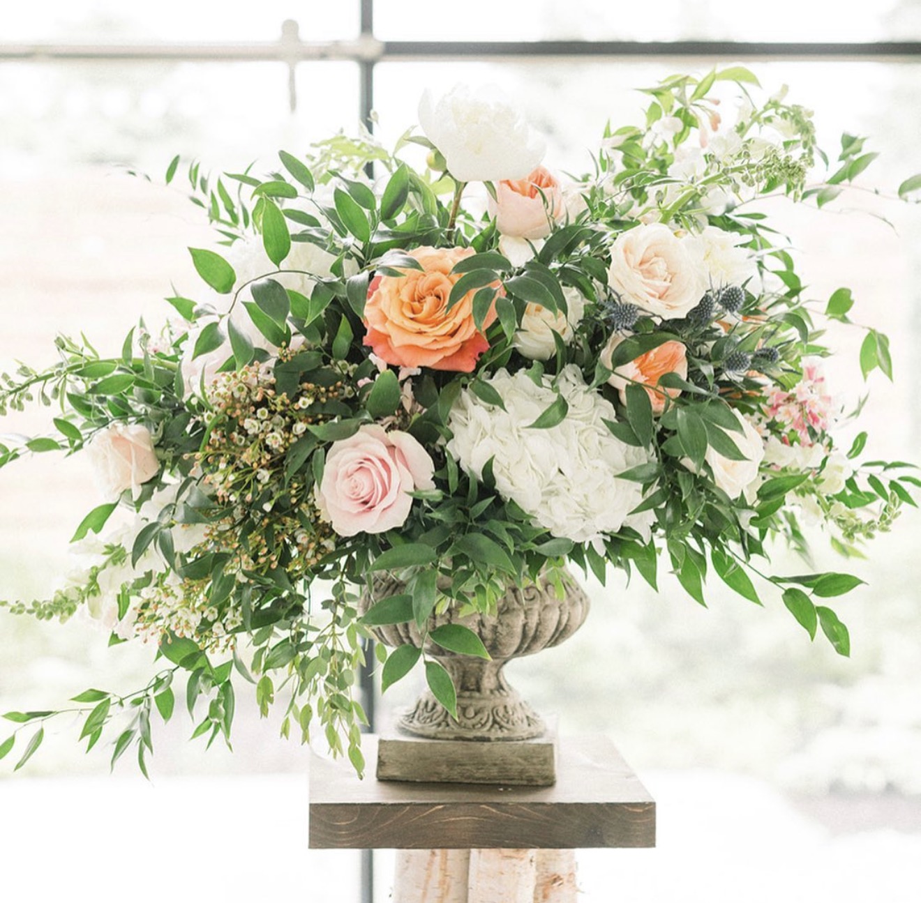 Pink peony and garden rose arrangement in a white vase for a Calgary wedding