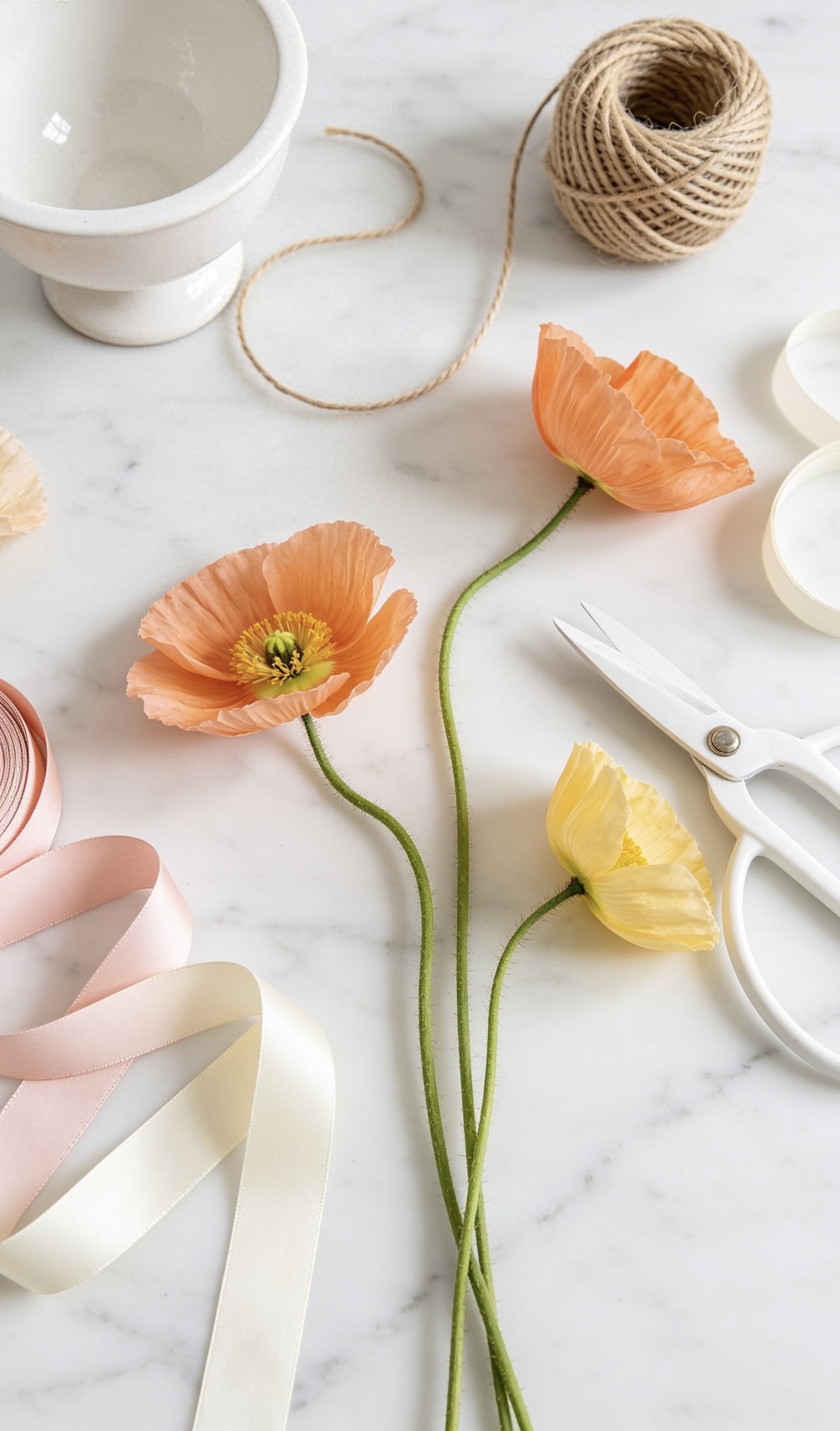 Poppies, twine, ribbon and scissors on a marble table at an Oh Flora floral workshop in Calgary